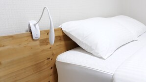 Cabecera de madera con almohada y colchón blancos.