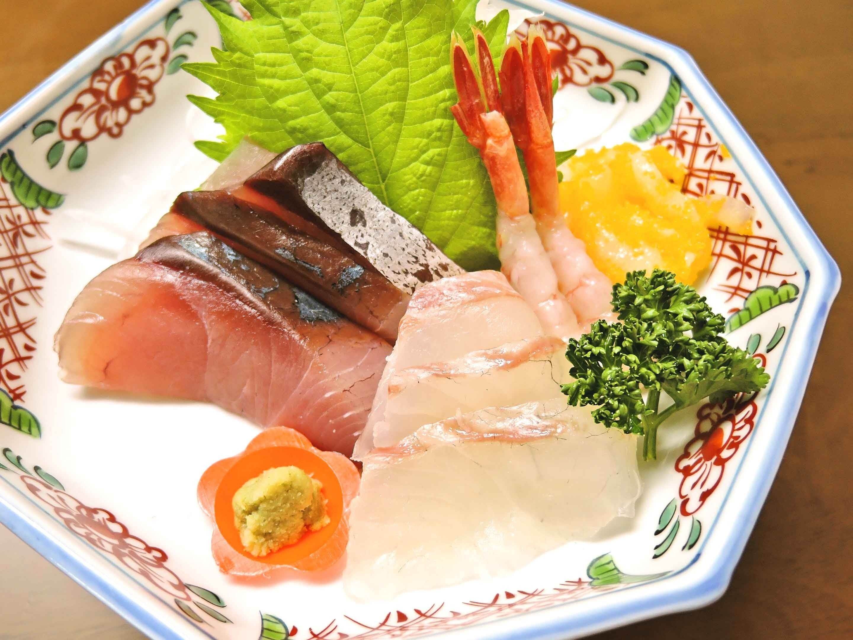 A plate with various sashimi and vegetables.