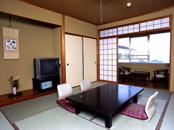 A traditional Japanese-style room with tatami flooring, a low table, and a television. - Matsushima Kanko Hotel MISAKITEI (Kamiamakusa)