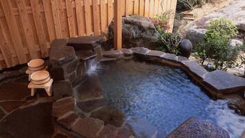 A hot spring with stone steps and wooden benches.