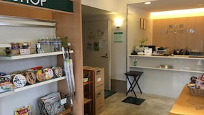 Tienda con estantes llenos de productos envasados y una zona de recepción con mostrador y escritorio.