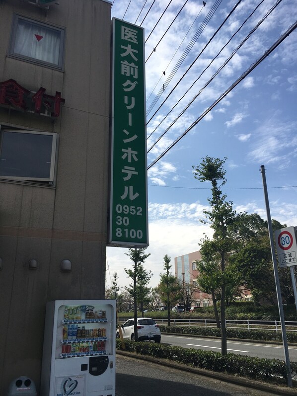 A building with a green sign indicating a medical facility. - Idaimae Green Hotel (Saga)