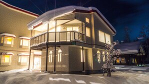 A multi-story building with balconies and a snow-covered roof. - BLISS Villa TSUBAKI (Kutchan)