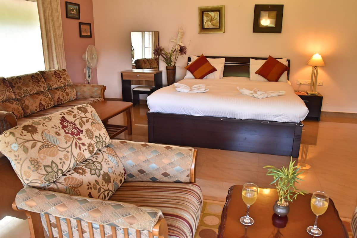 Ein Hotelzimmer mit Bett, Schlafsofa, Schreibtisch und zwei Nachttischen.