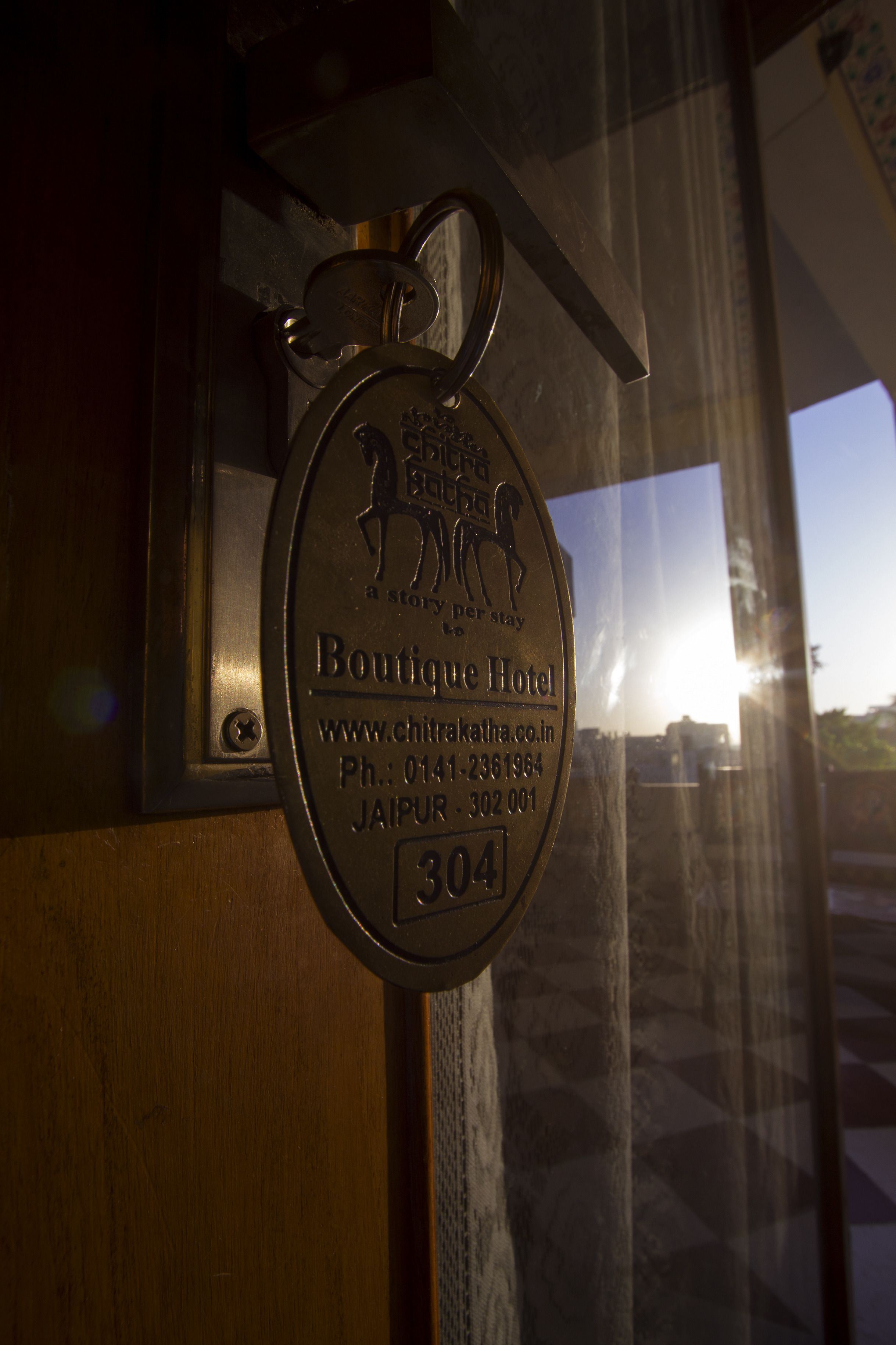 Una placa metálica con el nombre "Boutique Hotel" e información de contacto.