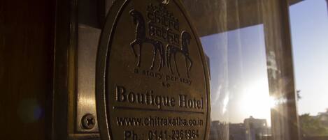 Una placa metálica con el nombre "Boutique Hotel" e información de contacto.