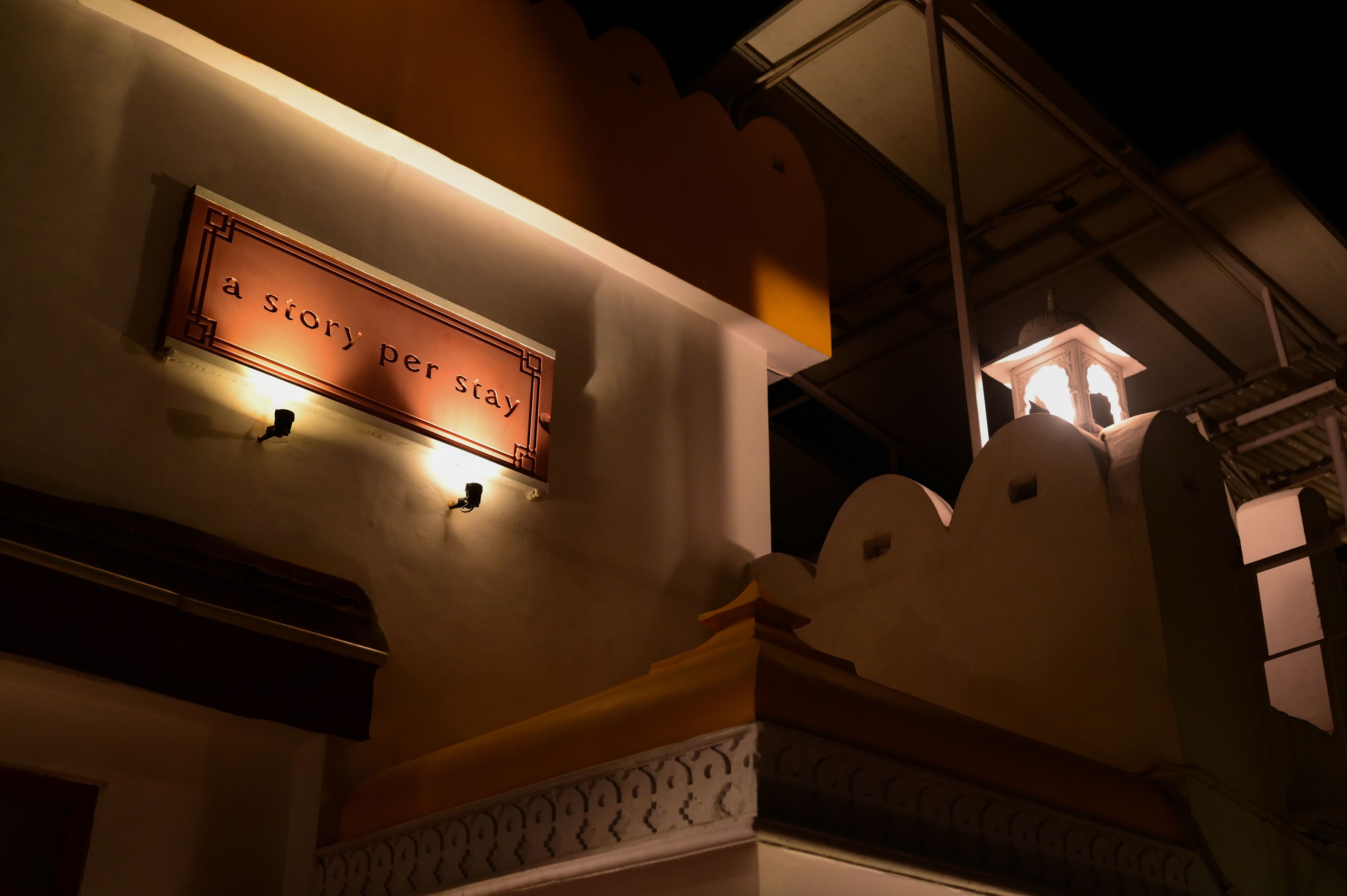A sign with the text "a story per stay" on a wall.