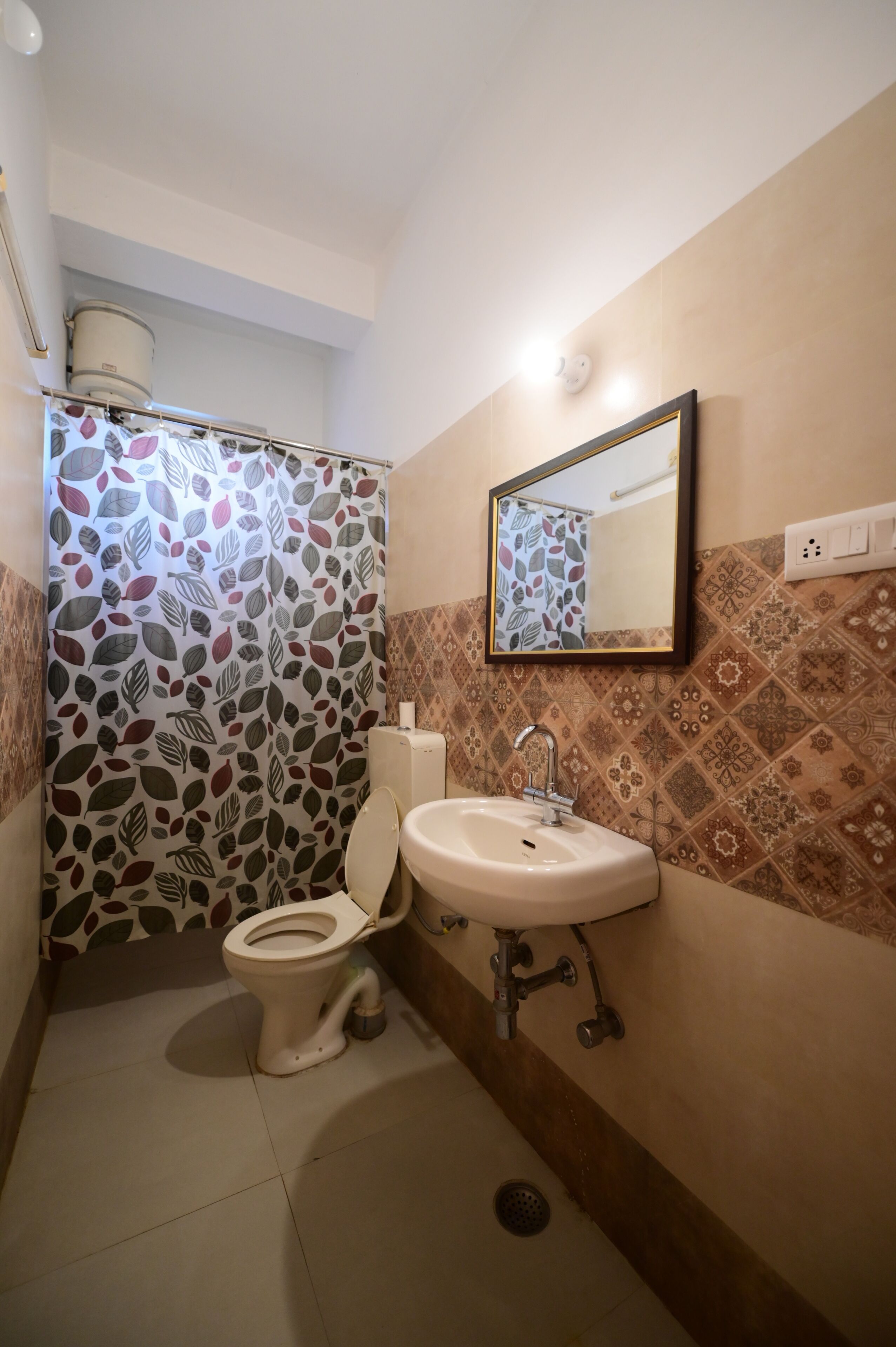 Une salle de bain équipée de toilettes, d’un lavabo et d’un rideau de douche.