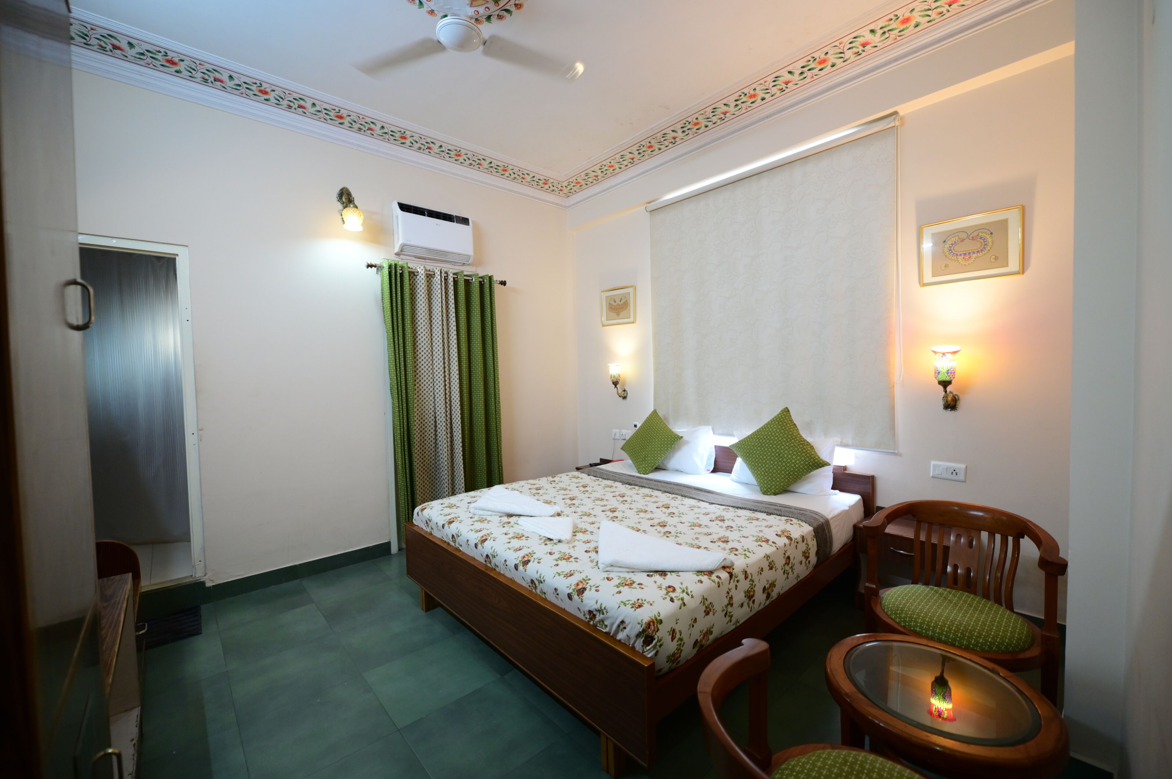 A neatly arranged bedroom with a bed, a chair, a small table, and a ceiling fan.