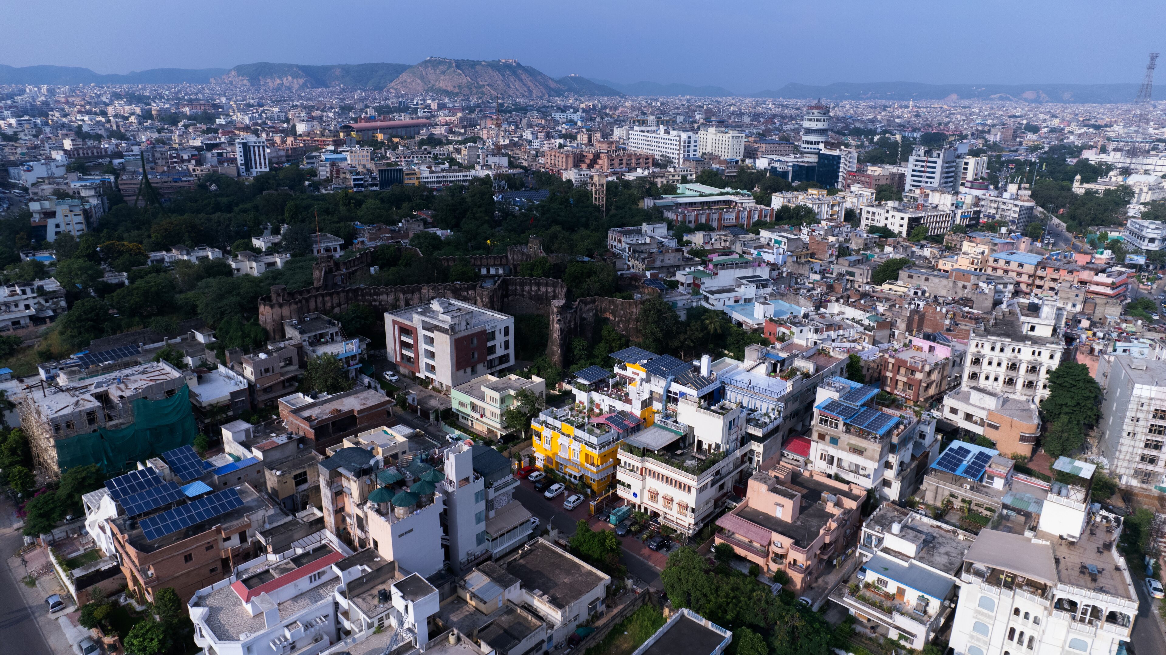 A densely packed urban area with various buildings, including some with solar panels on rooftops.