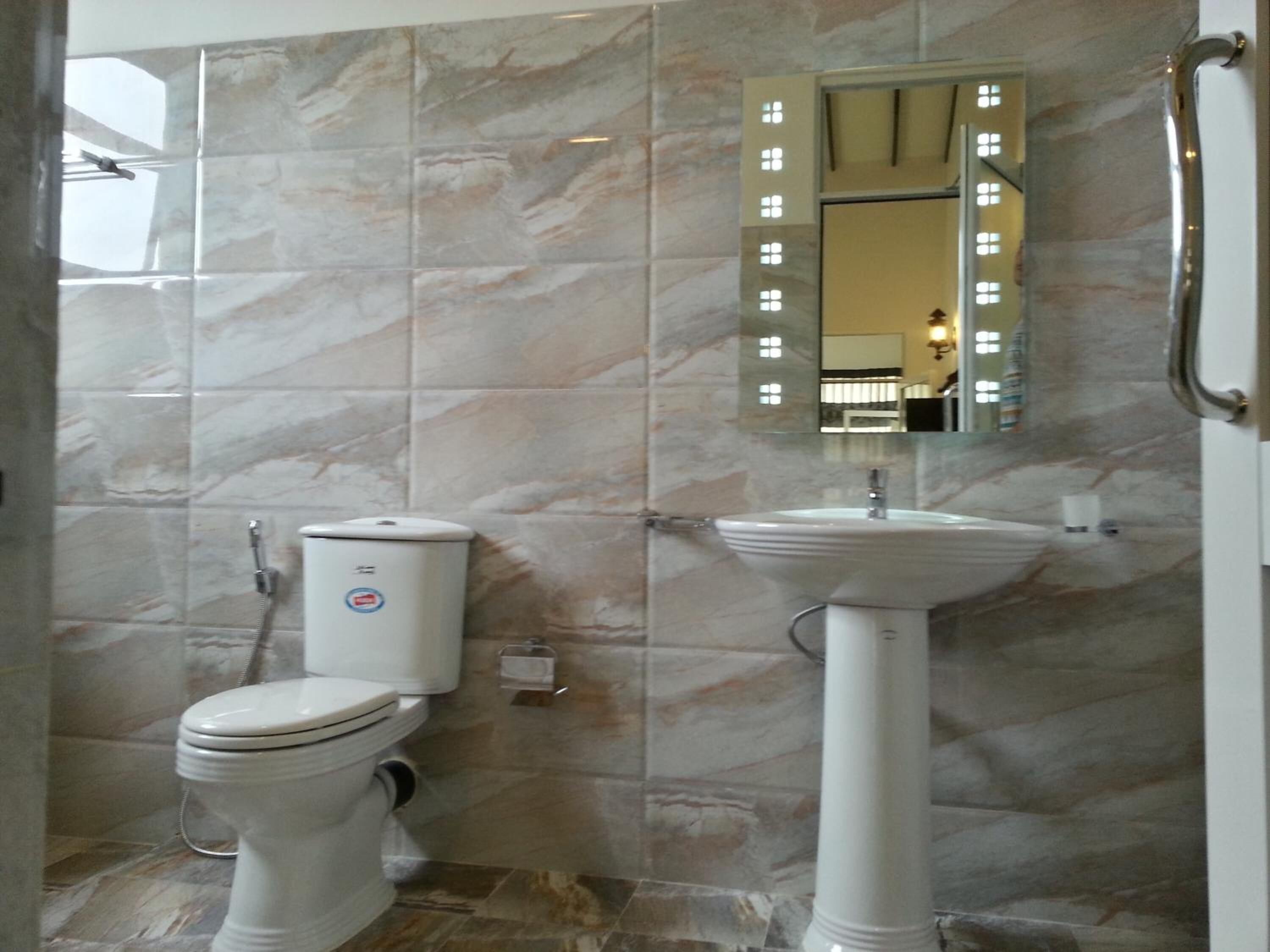 Une salle de bain équipée de toilettes, d’un lavabo et d’une douche.