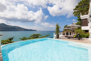 Una piscina con vistas al mar y a las montañas.