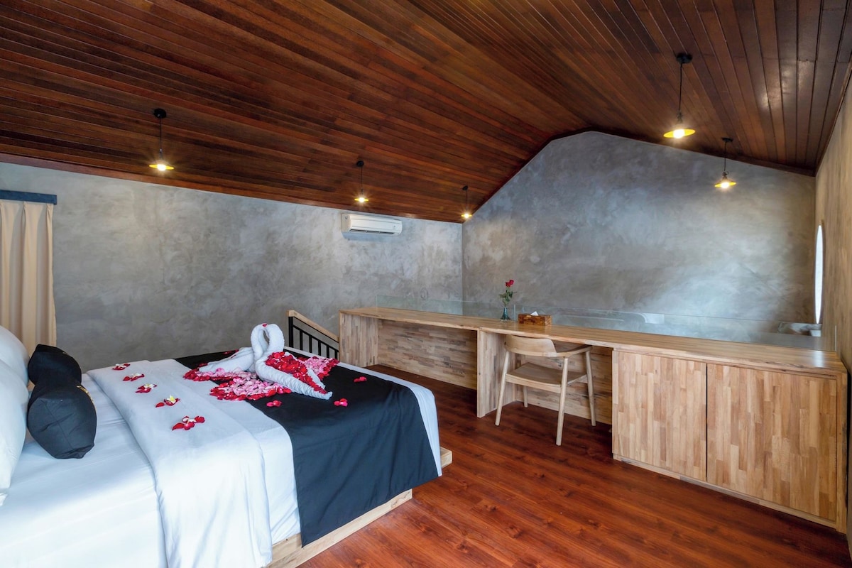 A bedroom with a bed, a desk, and a chair.