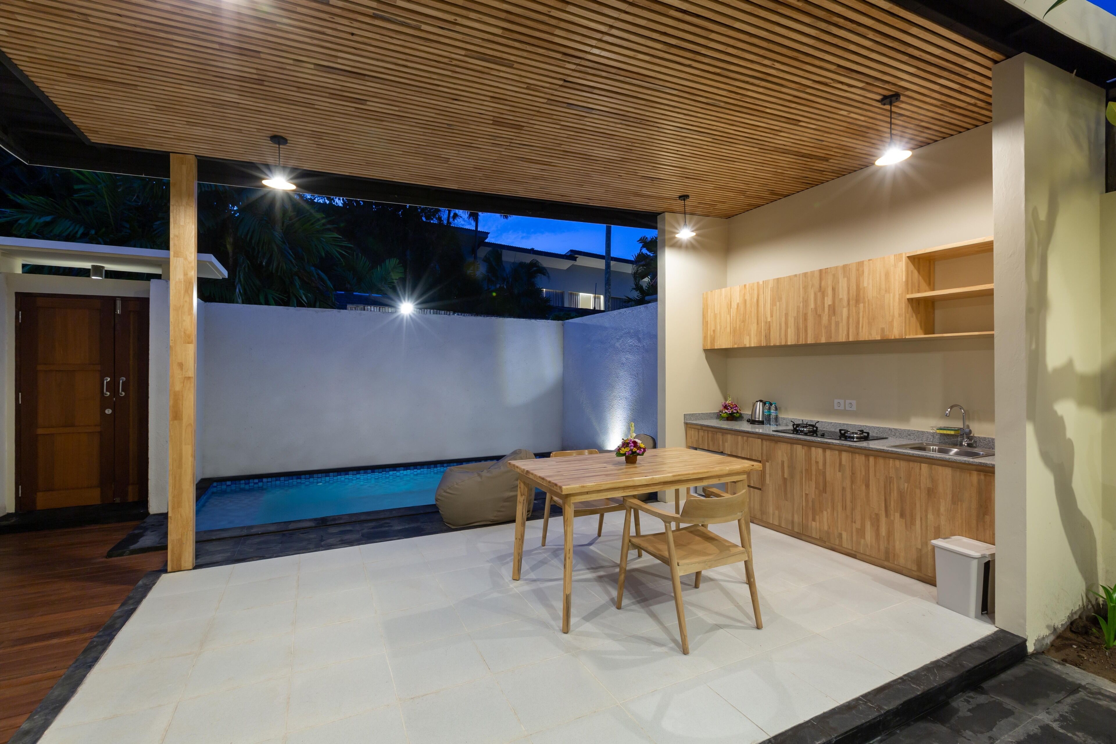 A modern kitchen with wooden cabinets and a dining area with a table and chairs.