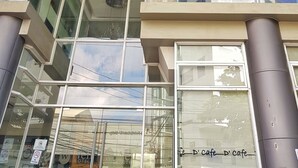 L’extérieur du Well Hotel présente un design moderne, avec de grandes fenêtres en verre et une enseigne bien visible.