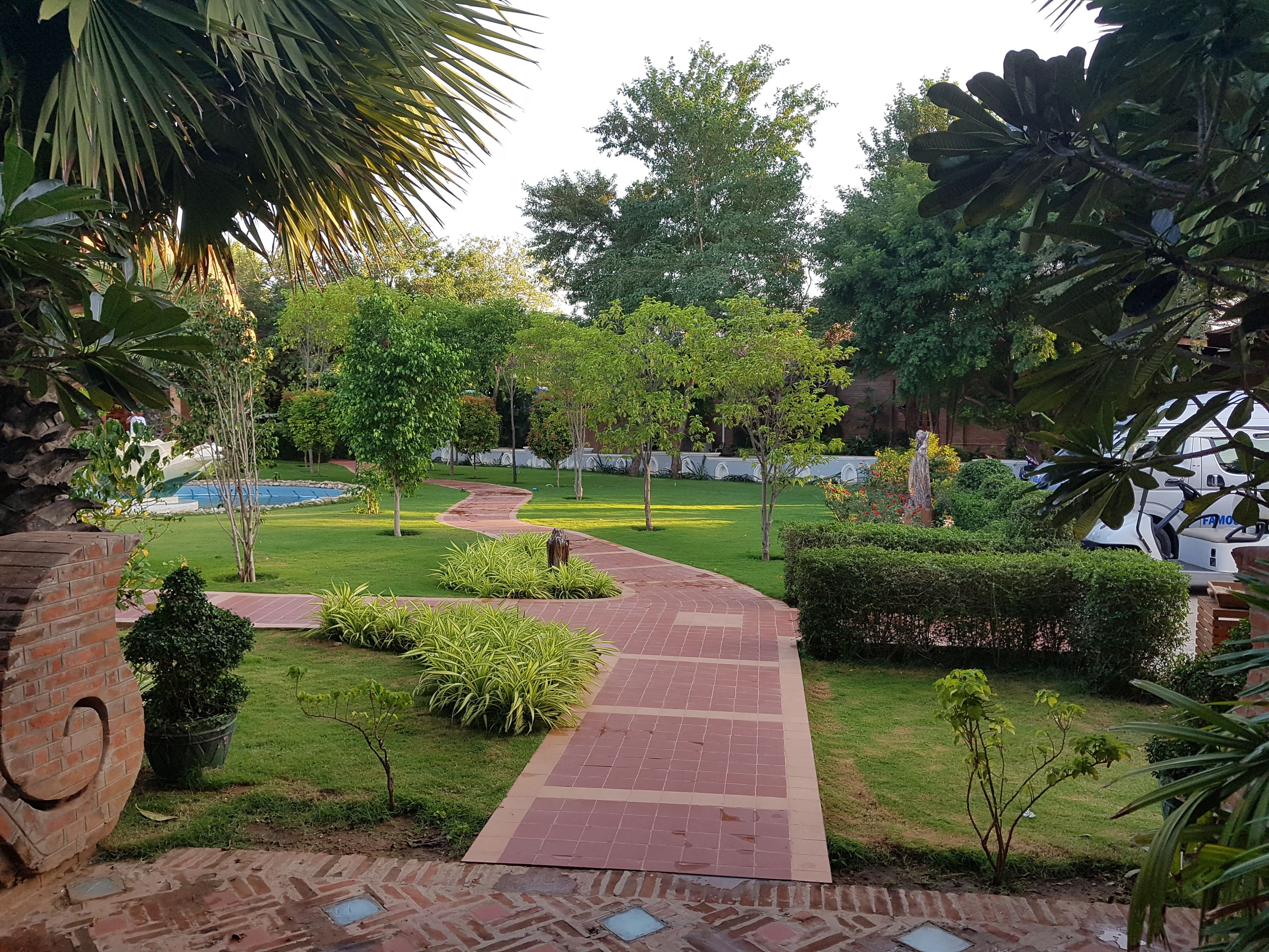A garden pathway leading to a building with a brick facade.