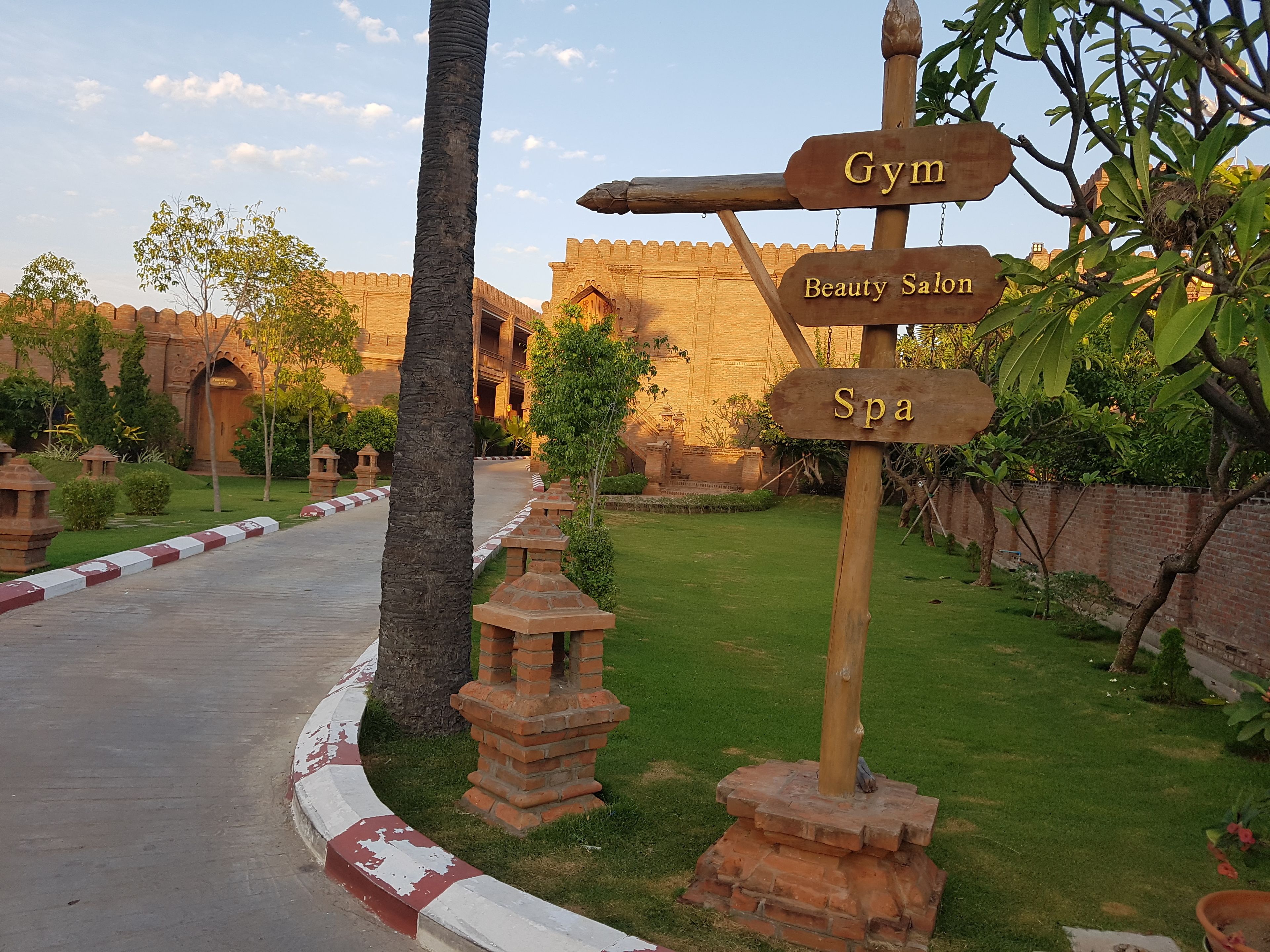A signpost with directions to a gym, beauty salon, and spa.