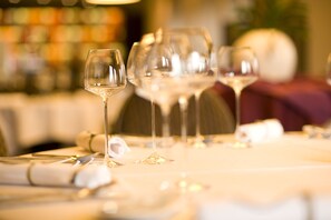 Una mesa dispuesta con copas de vino y cubiertos, lo que indica un comedor.