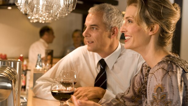 Un bar con una persona sosteniendo una copa de vino.