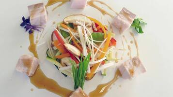 A dish with various vegetables and meat, arranged artistically on a plate.