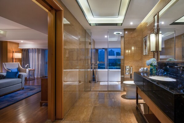 A modern hotel bathroom with a glass-enclosed shower, a large mirror, and a black marble sink. - Sentosa Hotel Apartment Taoyuan Branch (Shenzhen)