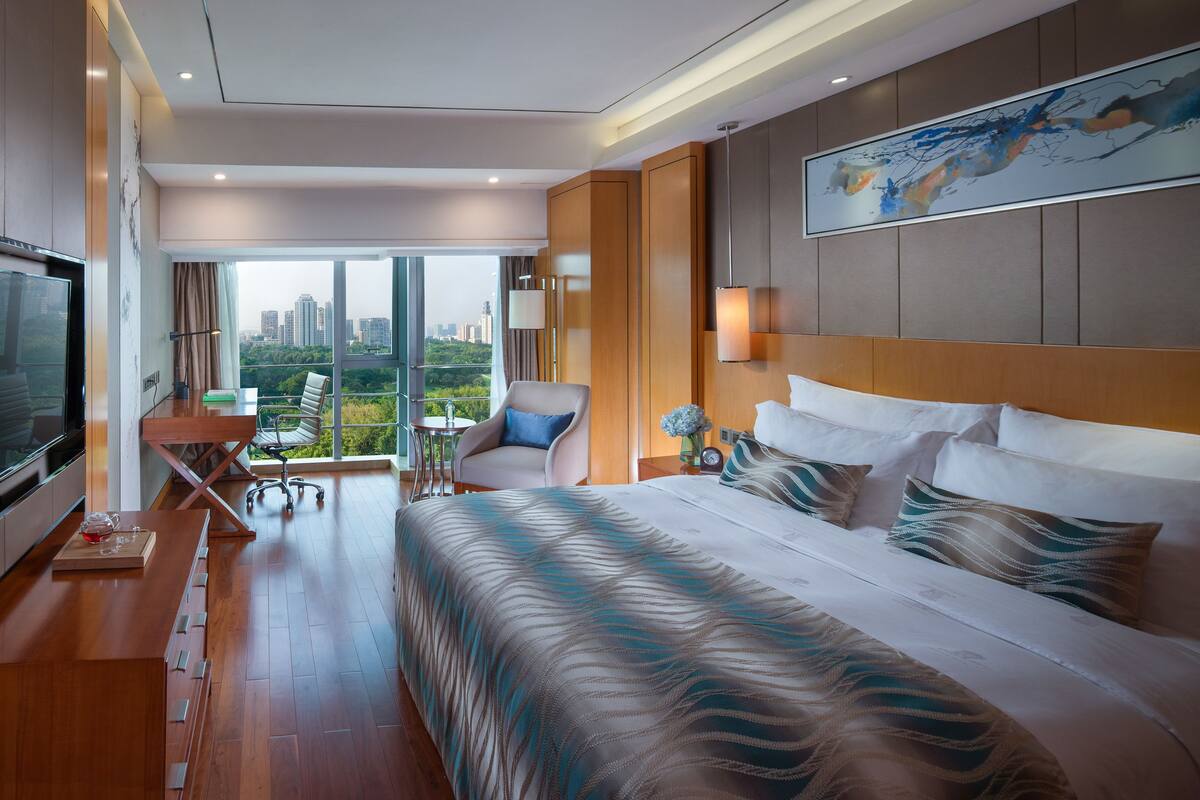 Une chambre d’hôtel moderne avec un grand lit, un bureau et une chaise.