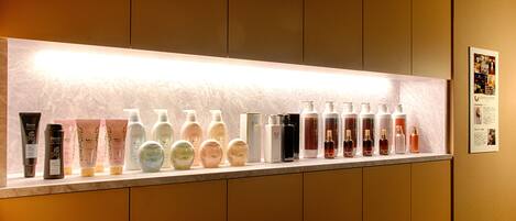 A display of various skincare products on a shelf in a hotel.