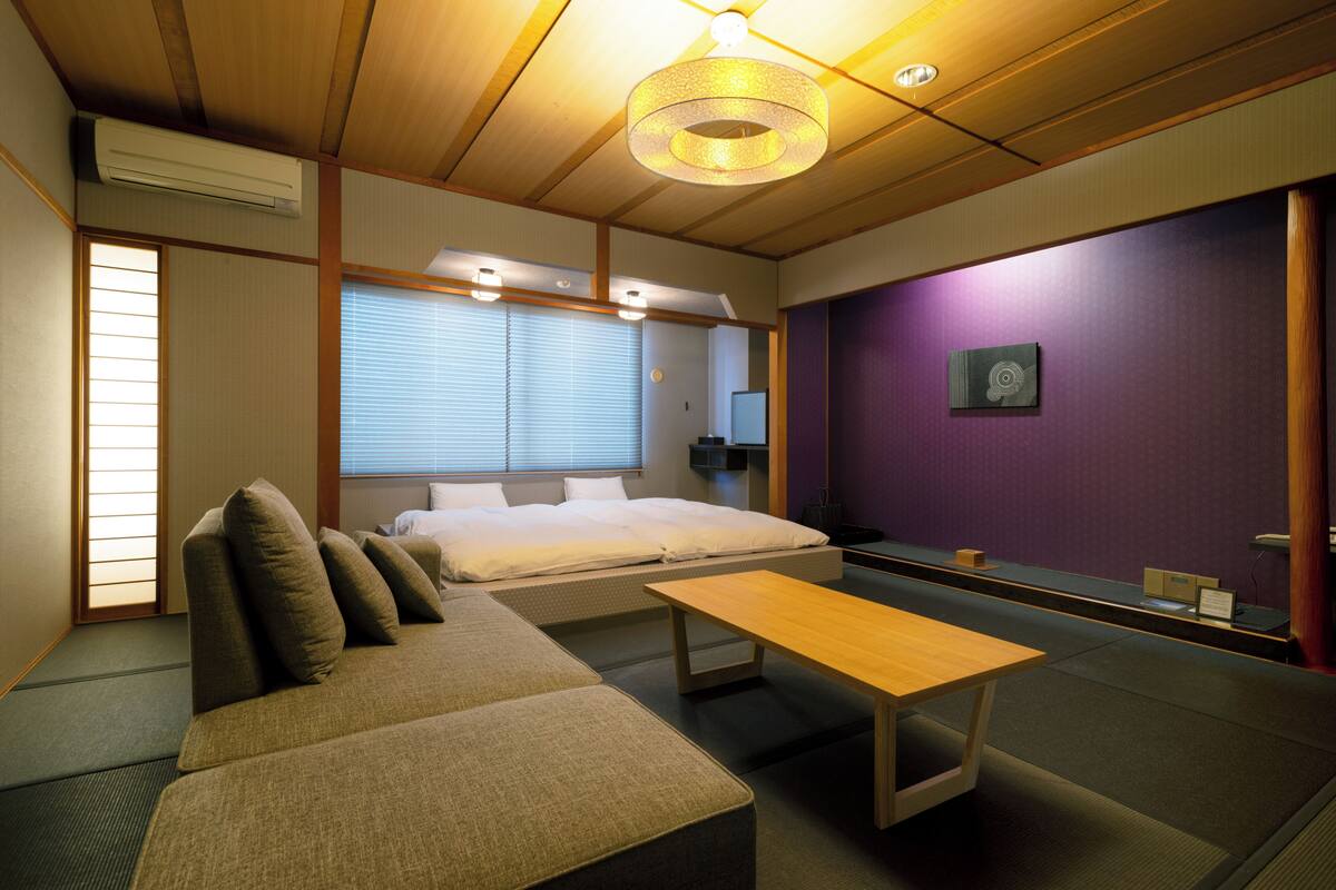 Une pièce comprenant un lit, un canapé, une table et un miroir.