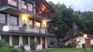 A two-story building with balconies, a stone facade, and a flag. - Ristoro Saint Roch (Hone)