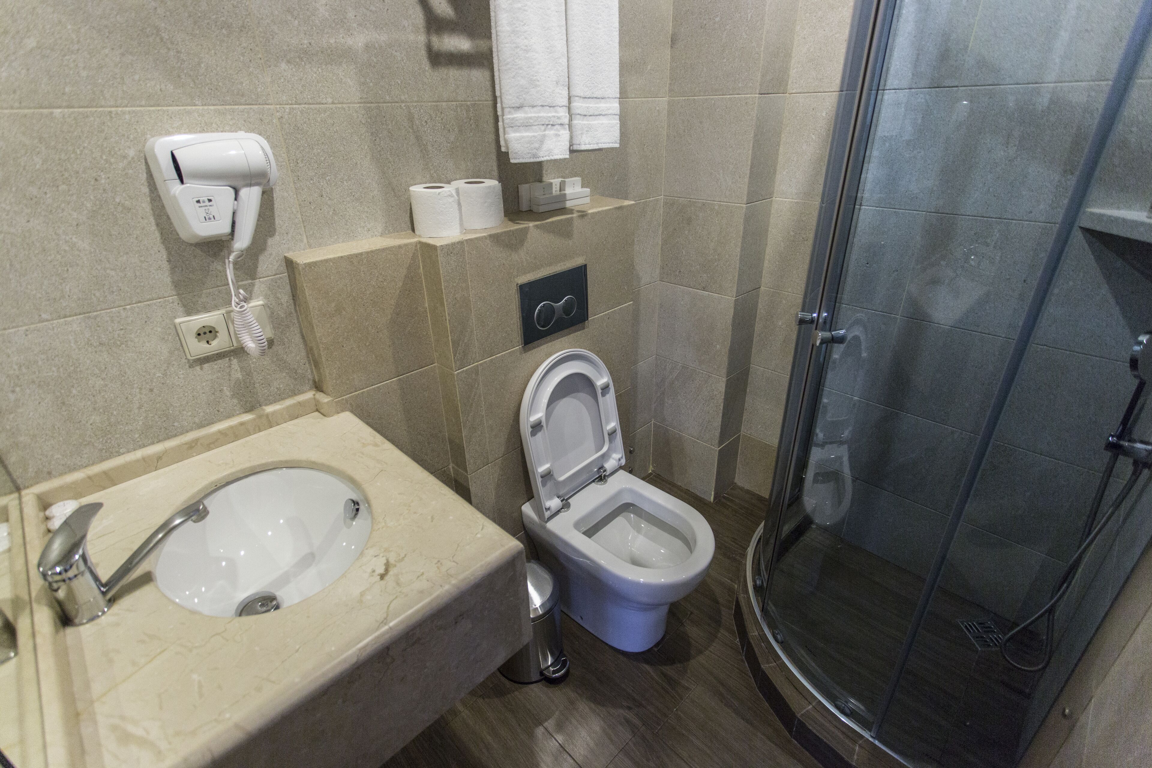 A bathroom with a sink, toilet, and shower.