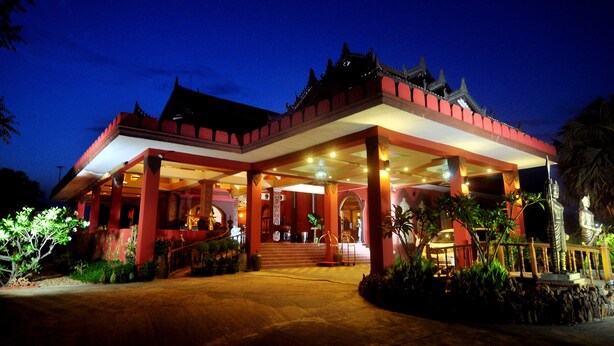 A traditional building with a red facade and a covered entrance area. - Gracious Bagan Hotel (Nyaung-U)