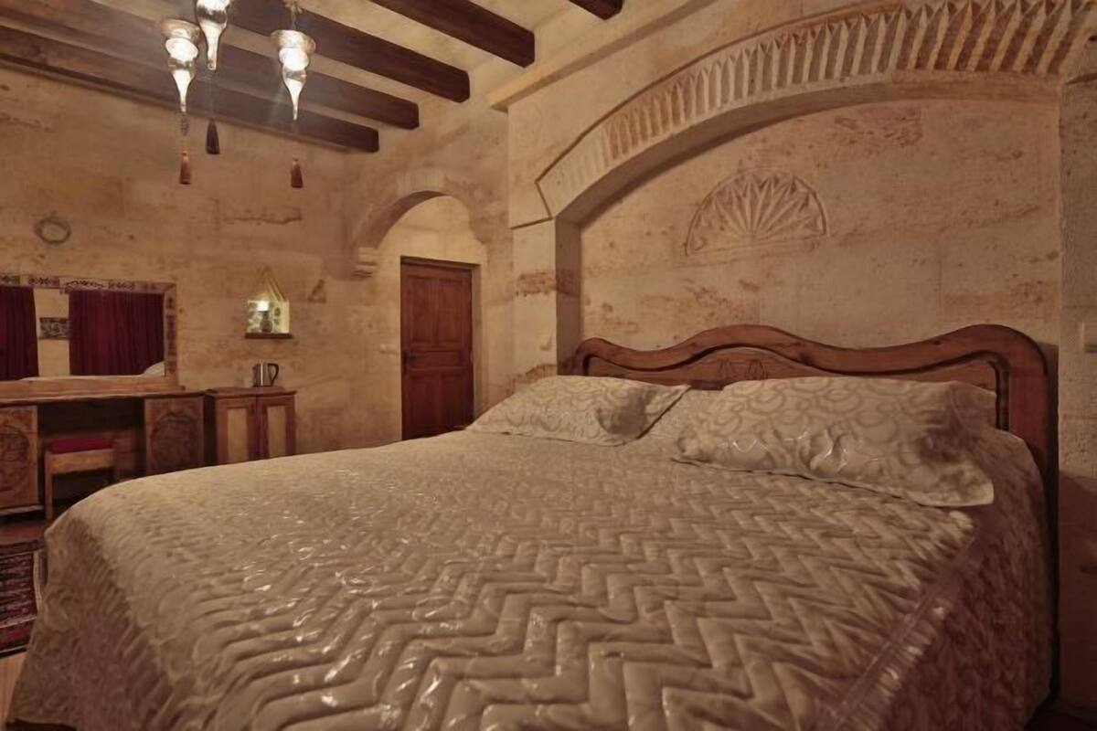 Ein Schlafzimmer mit einem großen Bett, einem Holzkopfende und einer Kristallleuchter.
