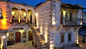 A historic building with a central staircase, multiple balconies, and arched doorways. - Harman Cave Hotel (Nevsehir)