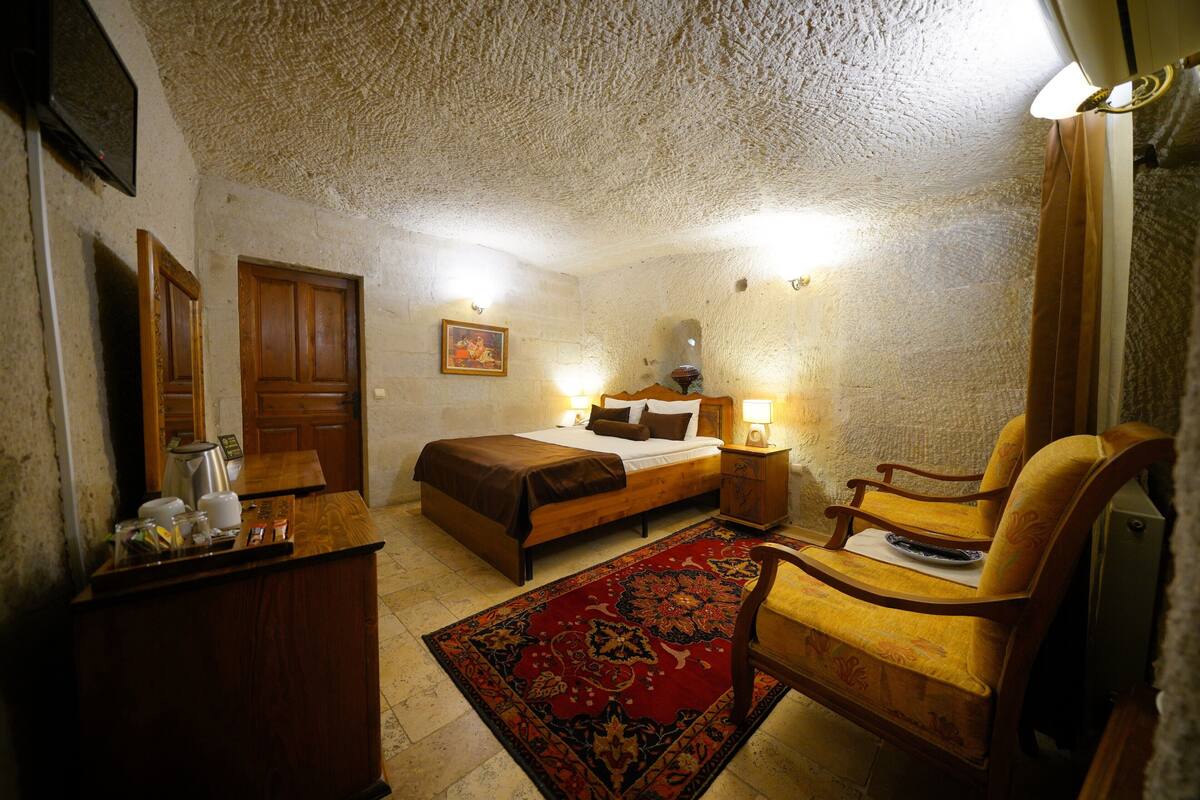 Ein Schlafzimmer mit Bett, Nachttisch, Stuhl und Teppich.