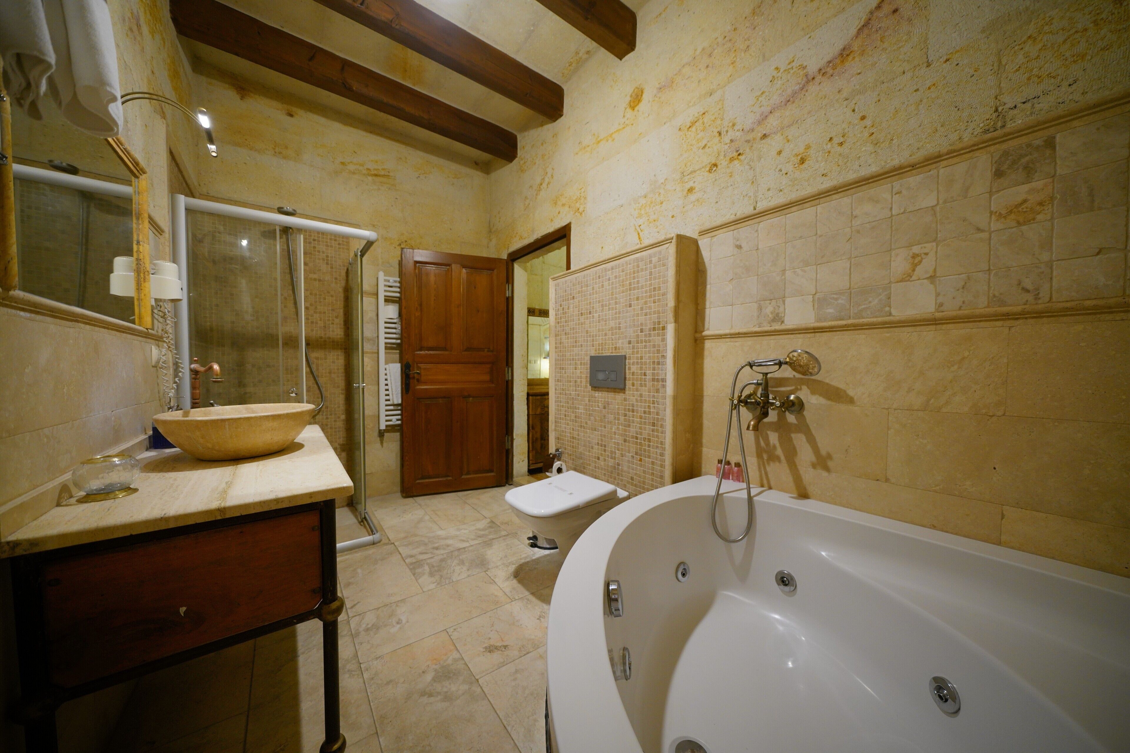 A bathroom with a bathtub, a sink, and a shower area.