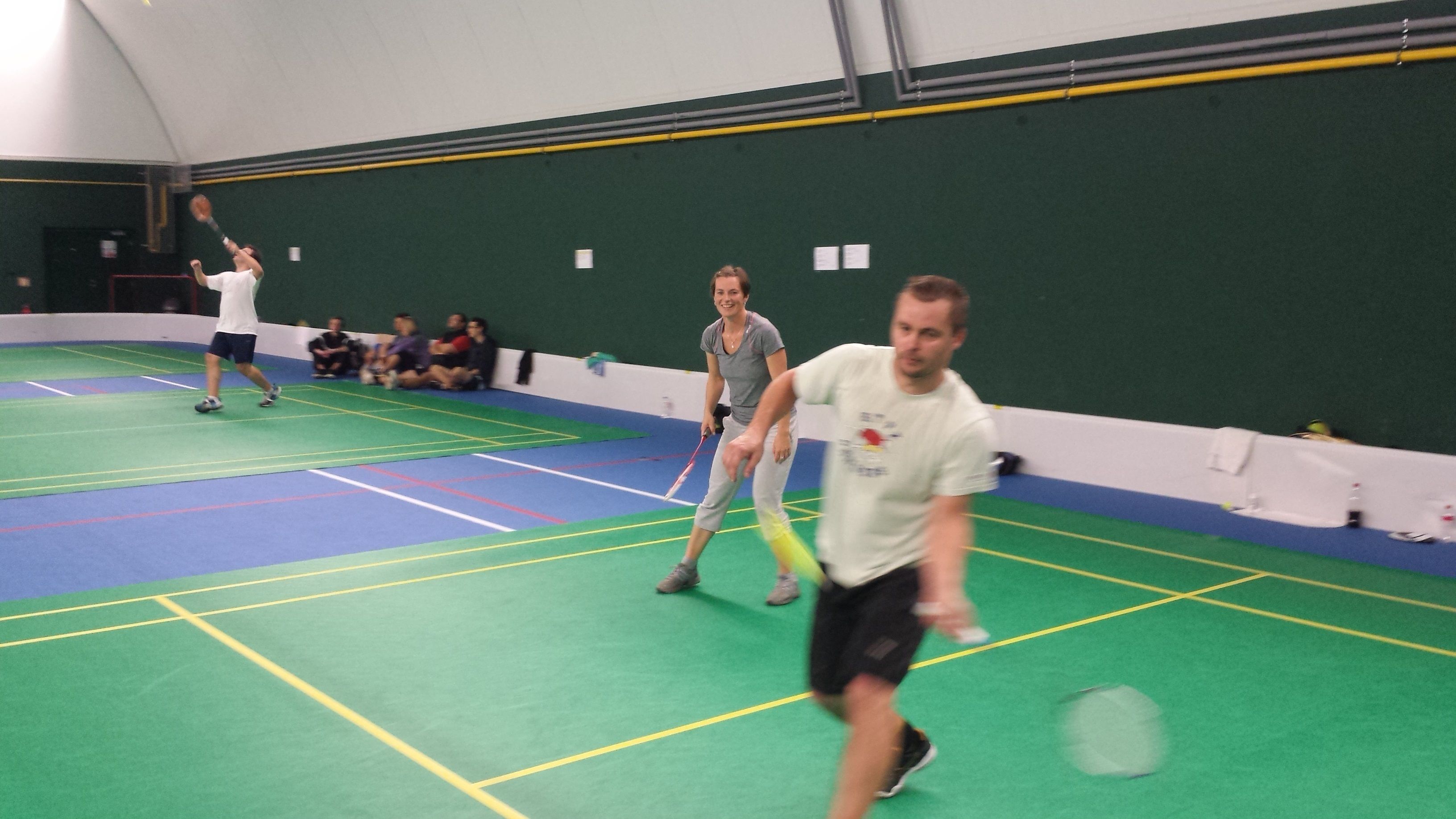 Un complexe sportif intérieur doté de plusieurs terrains, notamment un terrain de badminton et un terrain de tennis.