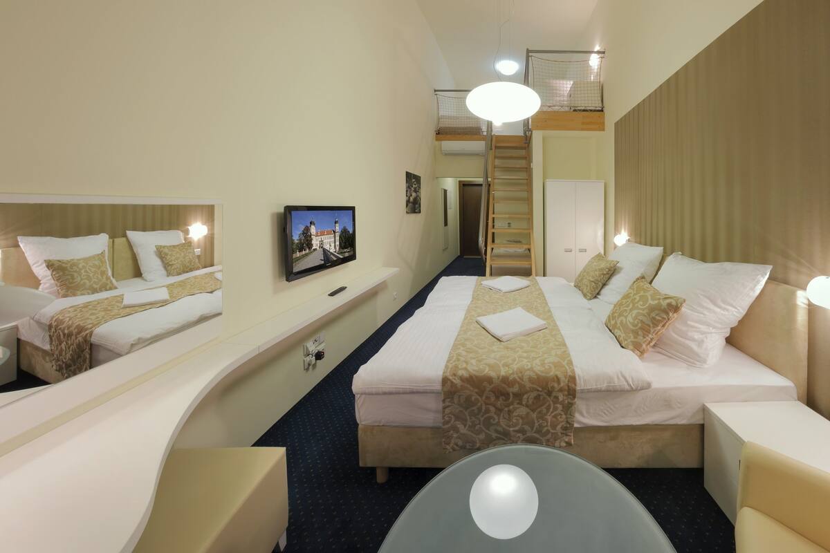 Hotelkamer met een groot bed, een televisie, een bureau en een balkon met uitzicht.