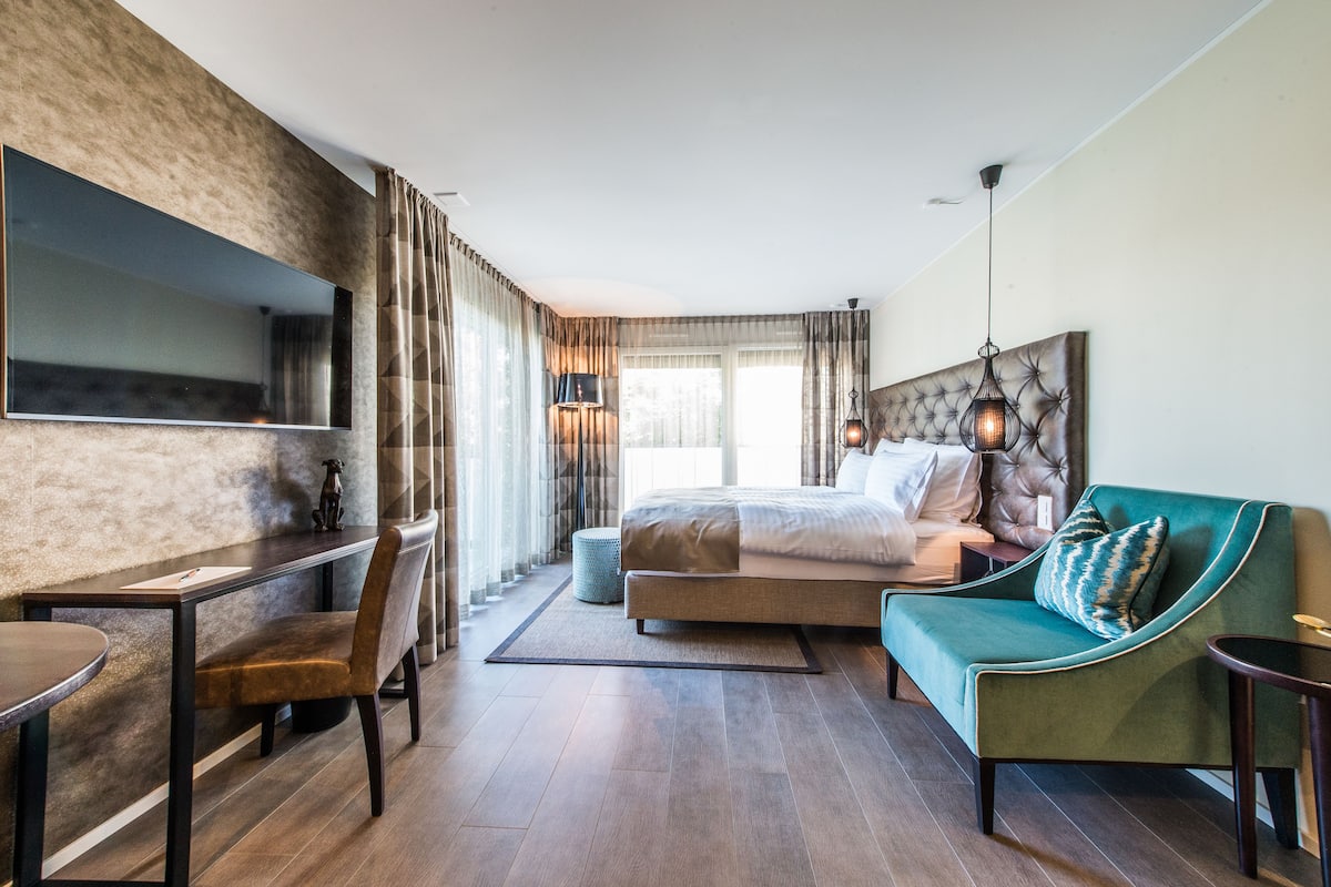 Ein modernes Hotelzimmer mit einem großen Bett, einem Schreibtisch und einer Sitzecke.