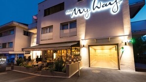 Ein Hotel namens "My Way" mit Restaurant und Bar, Außenbereich und einem gut beleuchteten Eingang.