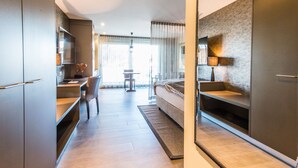 Ein modernes Hotelzimmer mit Küchenzeile, Essbereich und einem großen Bett.
