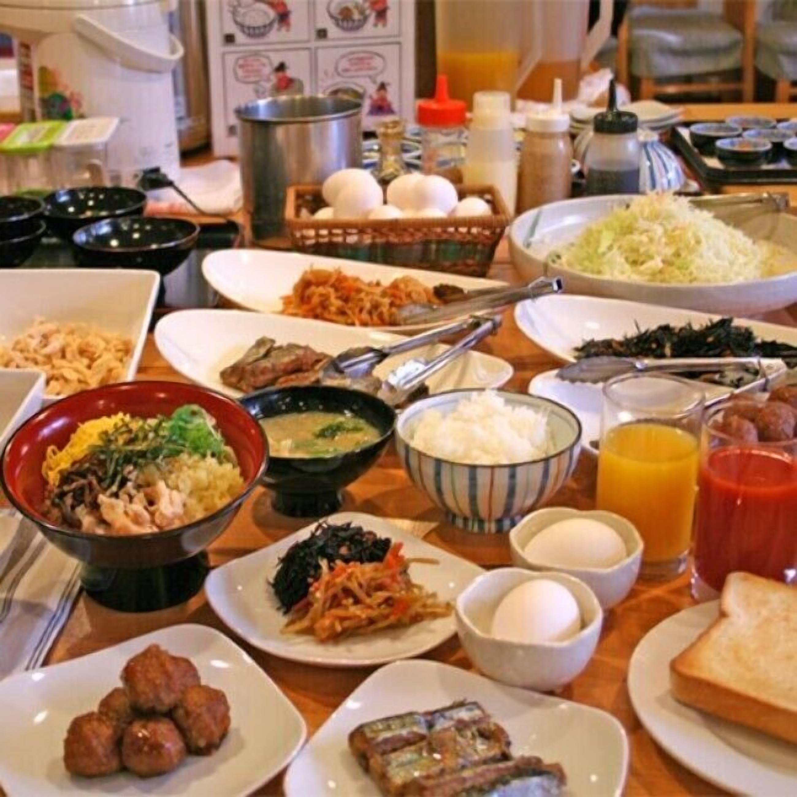 A table with various dishes including rice, soup, and meatballs.