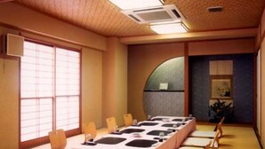 A conference room with a long table, chairs, and a large mirror on the wall.
