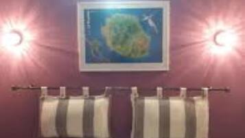 A bedroom with a bed, two towels hanging on a rack, and a wall-mounted picture.