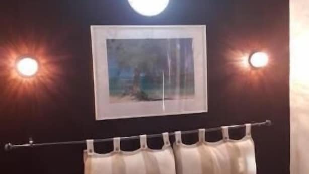 A bedroom with a bed, two bedside lamps, a framed picture on the wall, and an air conditioning unit. - Hotel Du Centre (Saint-Denis)