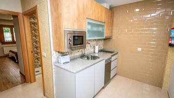 Una cucina moderna dotata di microonde, tostapane, lavello e lavastoviglie.