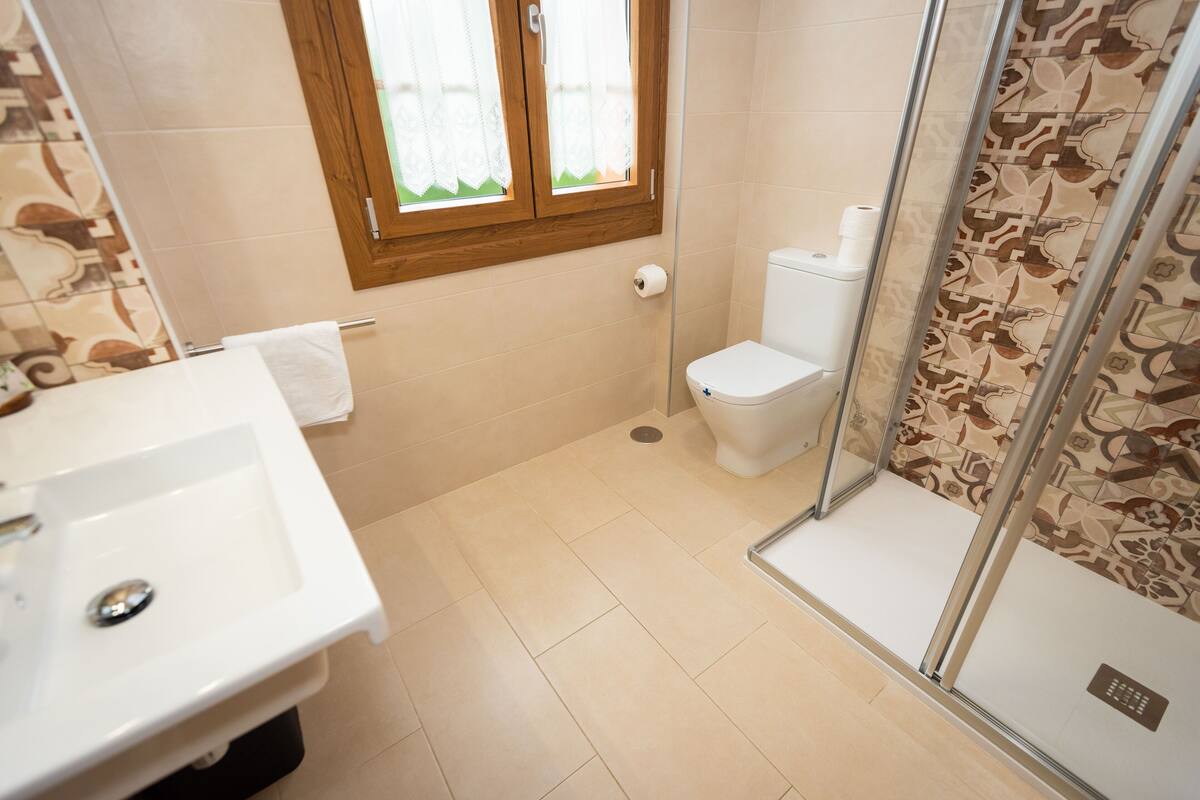 Un baño con lavabo, inodoro y zona de ducha.