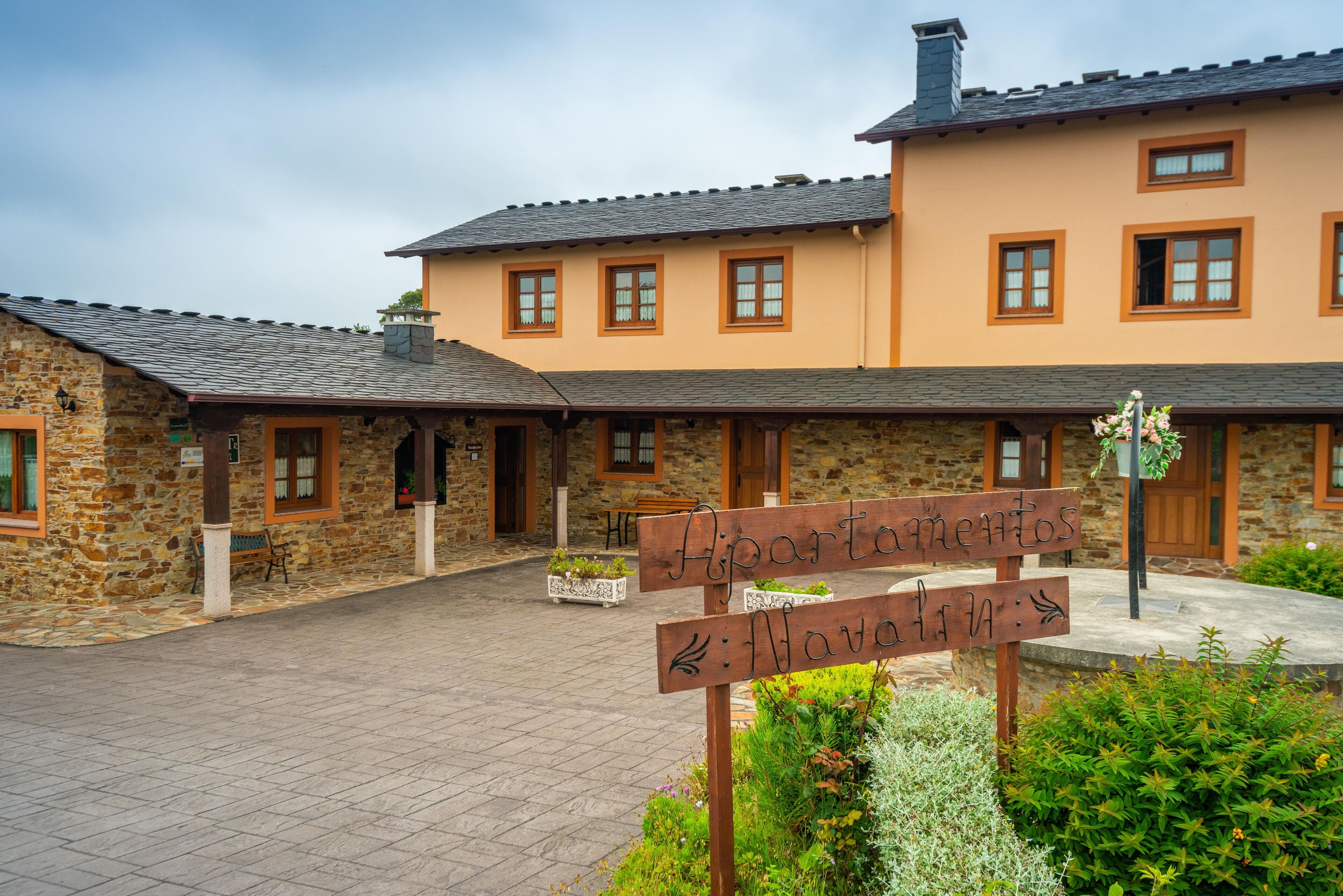 A stone building with a sign indicating "Apartamentos" and "Navalva".