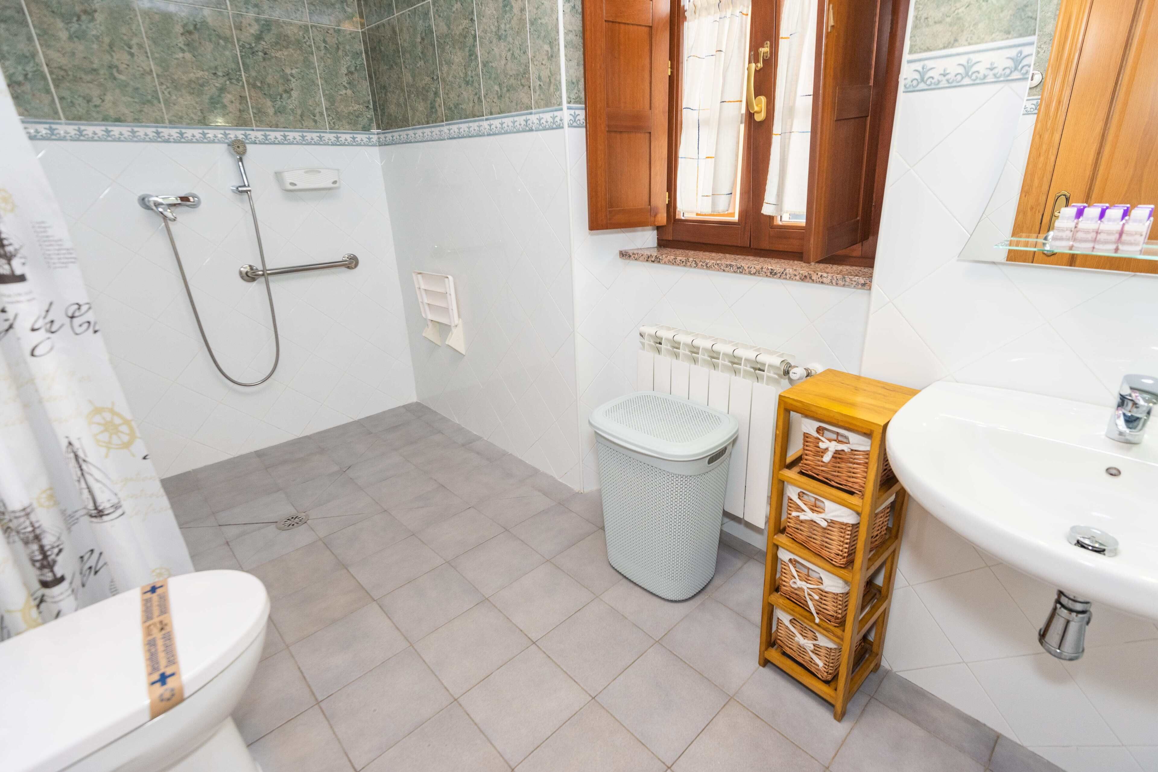 Un baño con inodoro, ducha, lavabo y un esparacero.