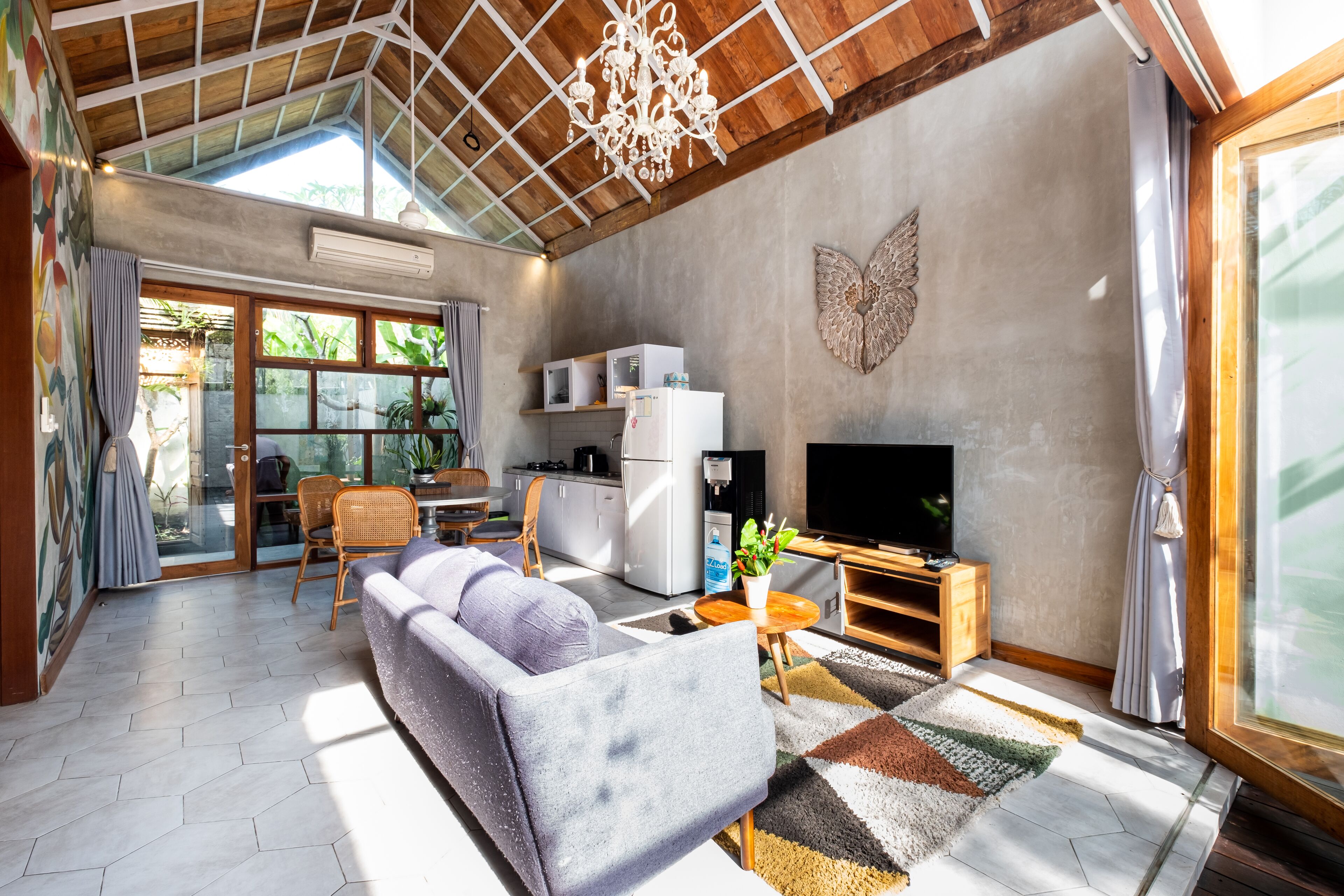 Amplia sala de estar con sofá, televisor y zona de cocina.
