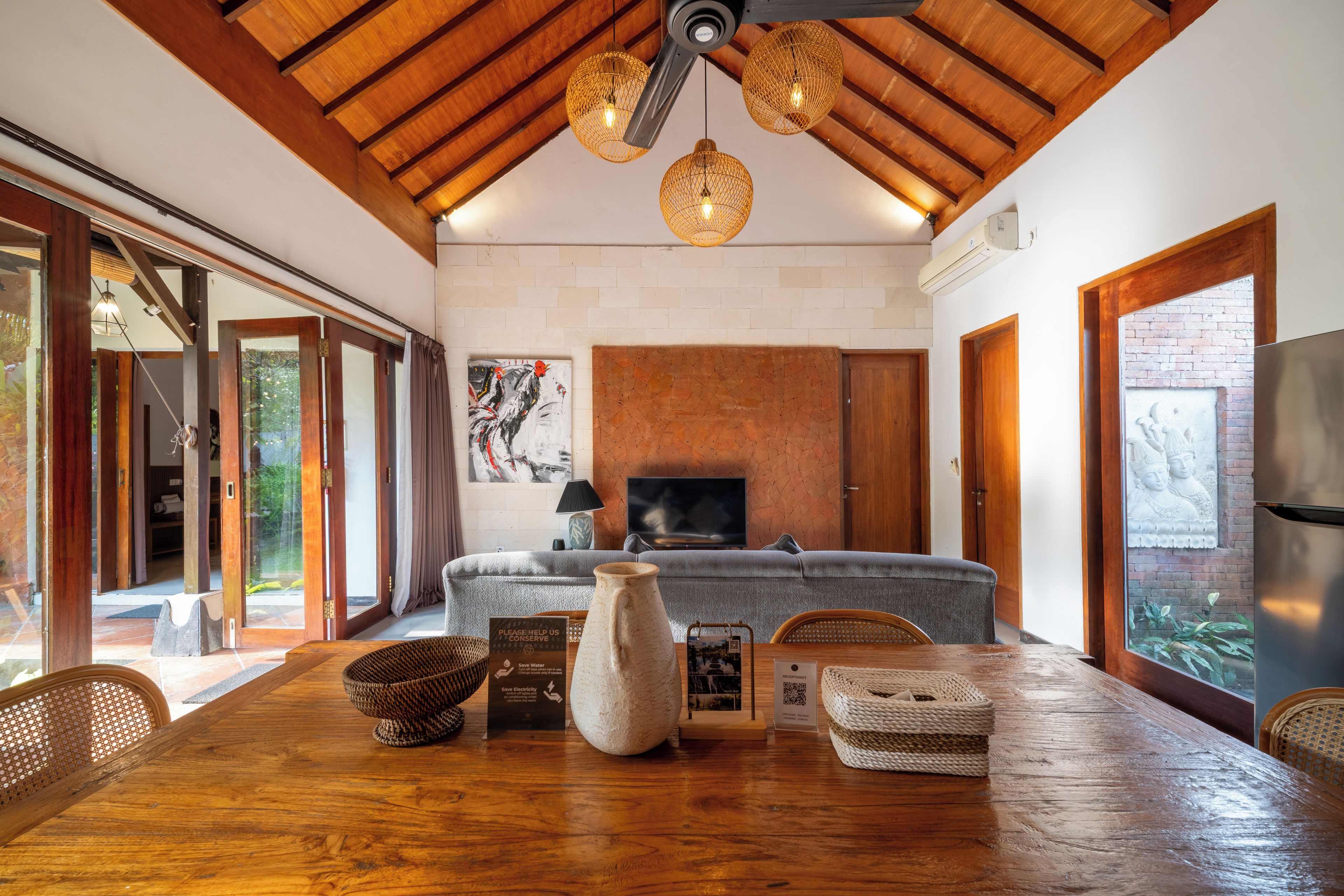 A spacious living room with a fireplace, wooden flooring, and a large sofa.